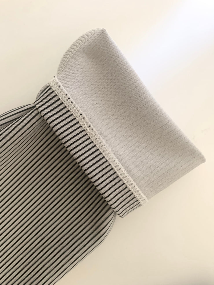 Sleeve photo of black, grey and white striped shirt flipped inside out.