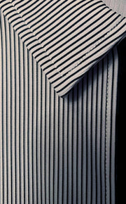 close up of the collar and partial black zipper of a black, grey and white striped shirt. 