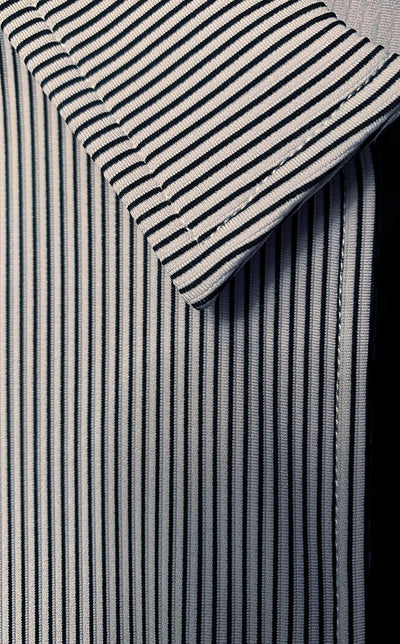 close up of the collar and partial black zipper of a black, grey and white striped shirt. 